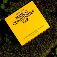 Yellow conditioner bar packaging on a green moss background